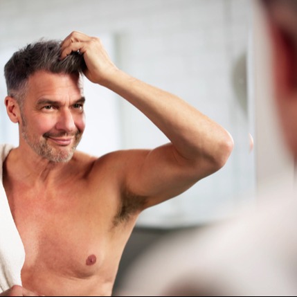 Happy Man Applying Hair Regrowth Treatment