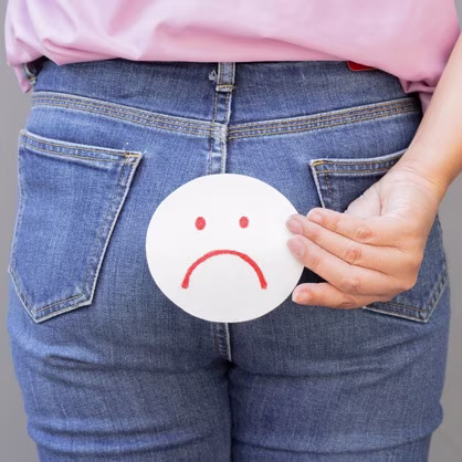 woman suffering from constipation and holding a paper with a sad face on a light gray background waiting for dulcolax to take effect 