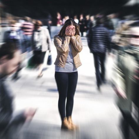 Woman amidst crowds of people in the city faces anxiety crisis