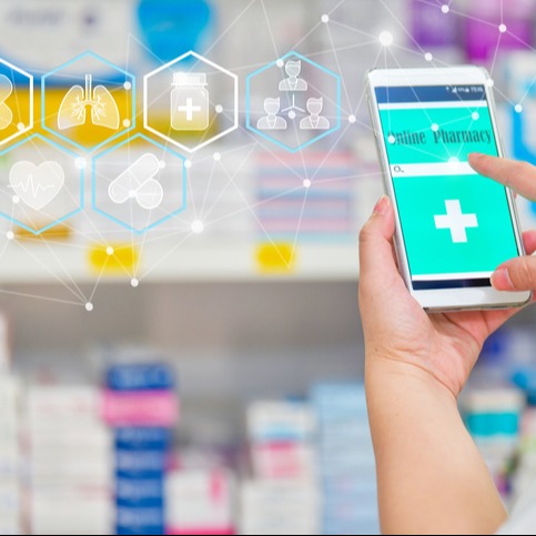 Pharmacist using mobile smart phone for search bar on display in pharmacy