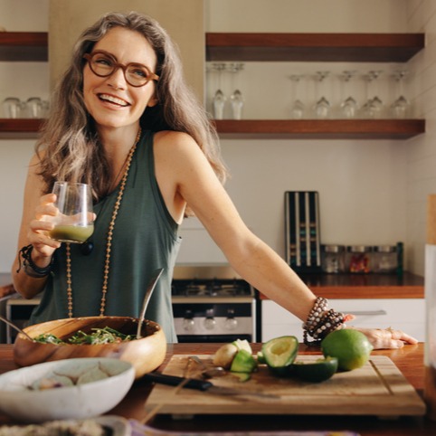 Healthy senior woman smiling while holding some green juice