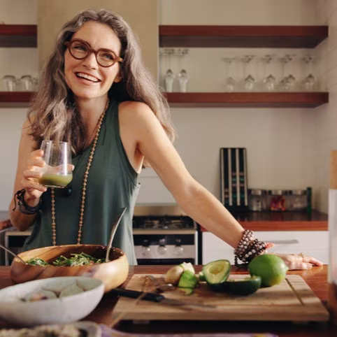 Healthy senior woman smiling while holding some green juice