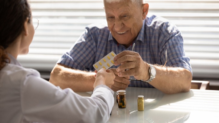 Therapist give medication to mature man
