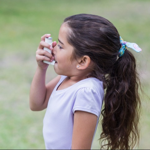 Little girl using his inhaler