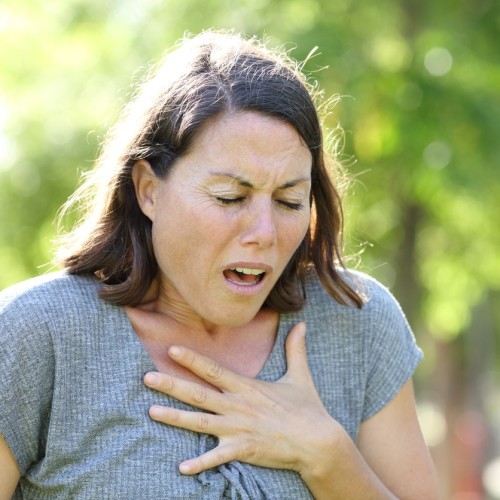 Middle age woman wheezing in a park COPD