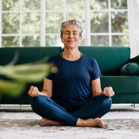 Senior woman meditating at home 