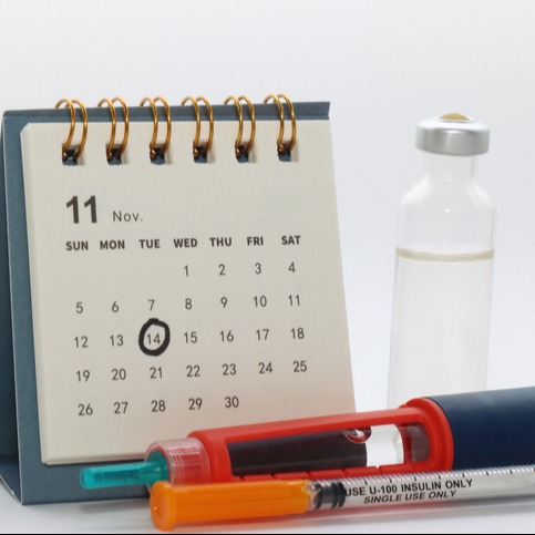 Calendar with World Diabetes Day marking and a vial of insulin, a semiglutide pen and syringe