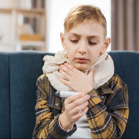 Sad tired sick asthmatic teenager with scarf around neck temperature check using thermometer