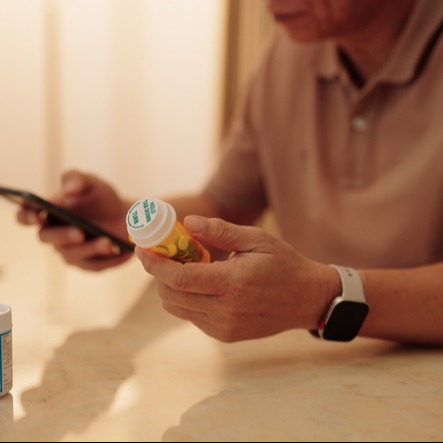 Senior Checking Apixaban Instructions with Smartphone