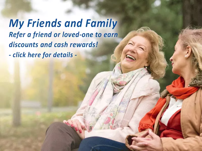 Two senior women sitting in park talking and laughing