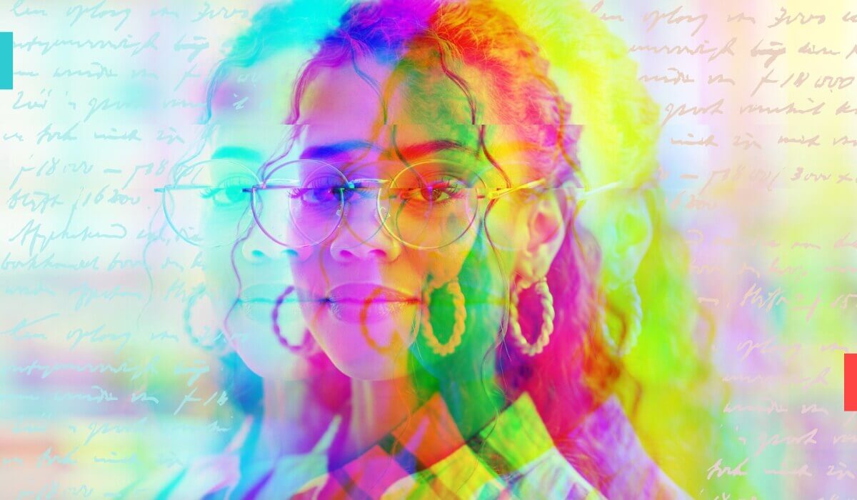 A woman in glasses poses against a vivid, colorful background.