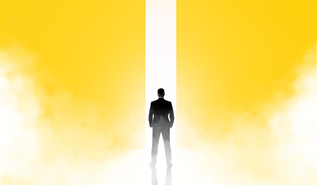 Man standing in front of yellow cloud split down the middle pondering a decision