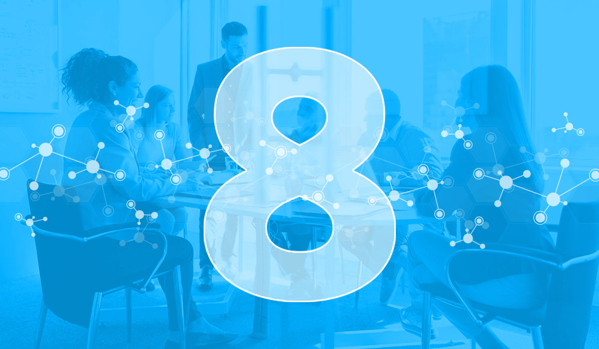 A group of employees seated at a table with a blue overlay and the number 8, representing the 8 HR analytics examples featured in this article.