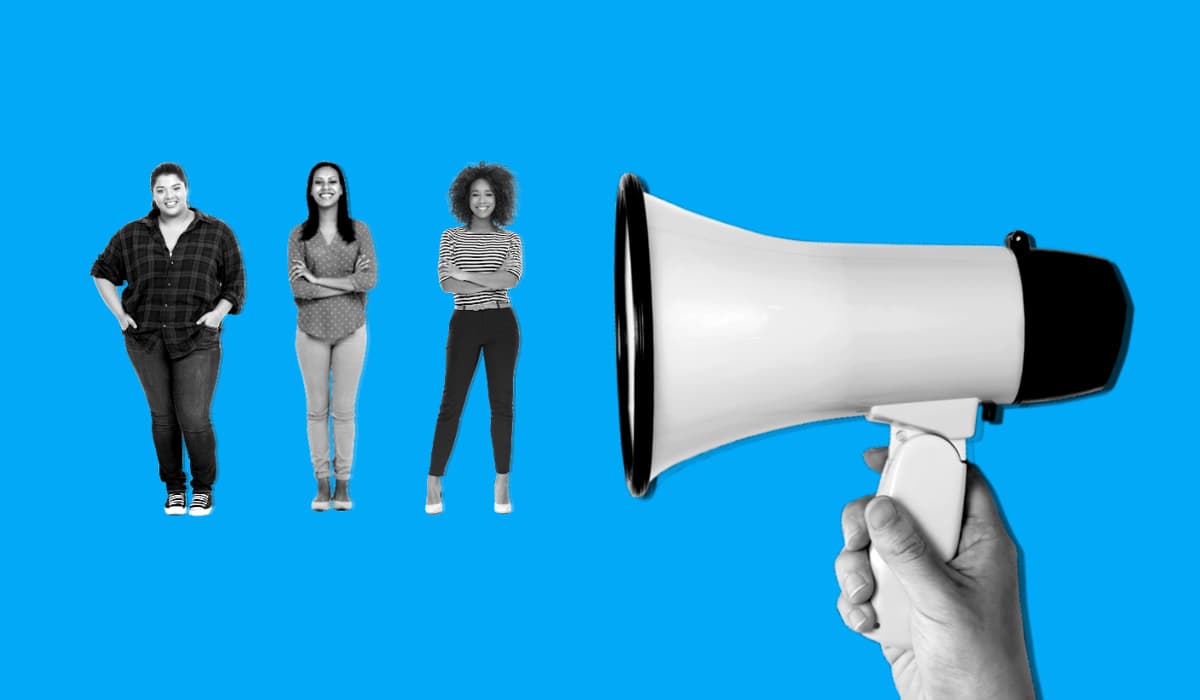 Three woman standing next to a megaphone