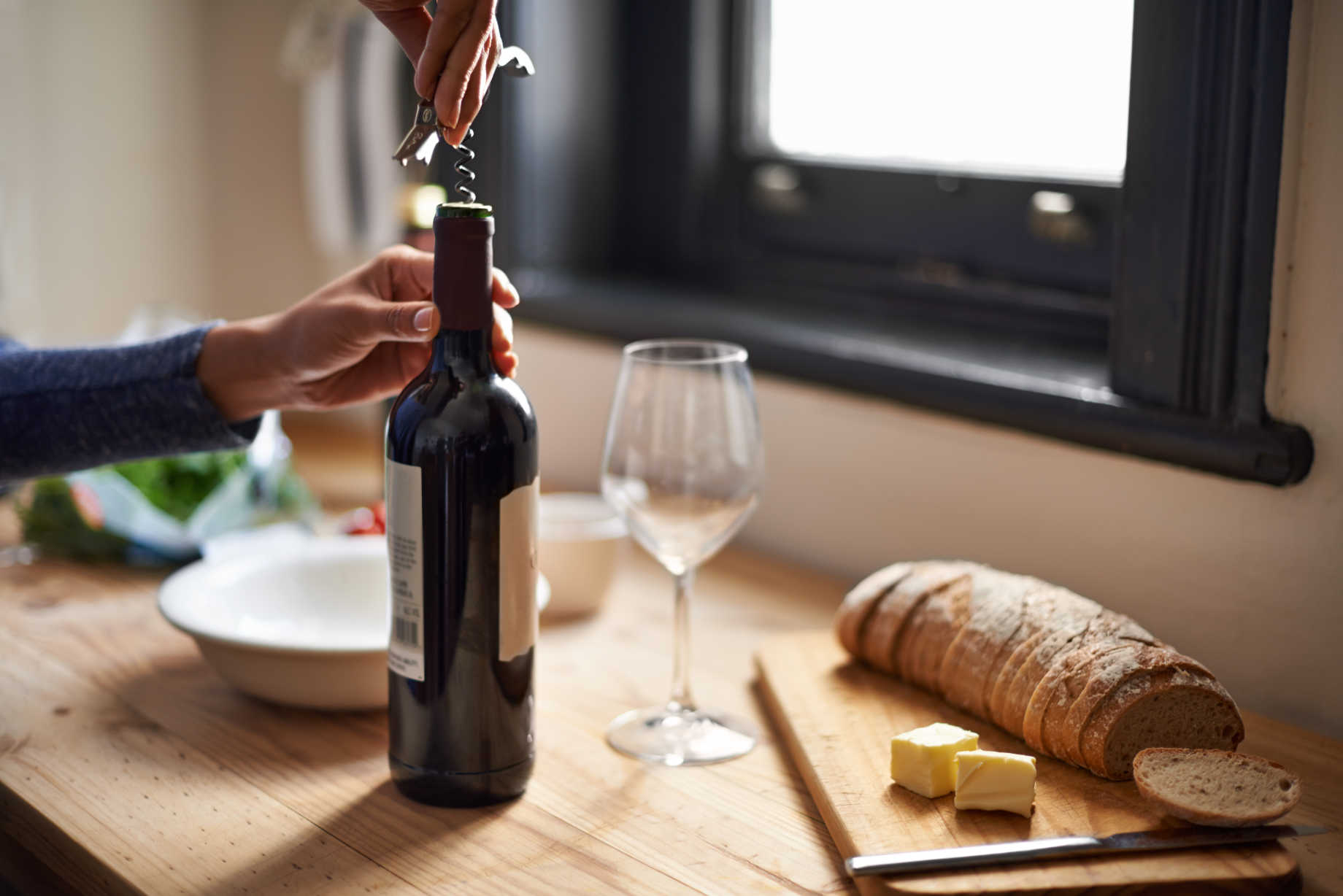 Vintage wine bottle being opened with corkscrew