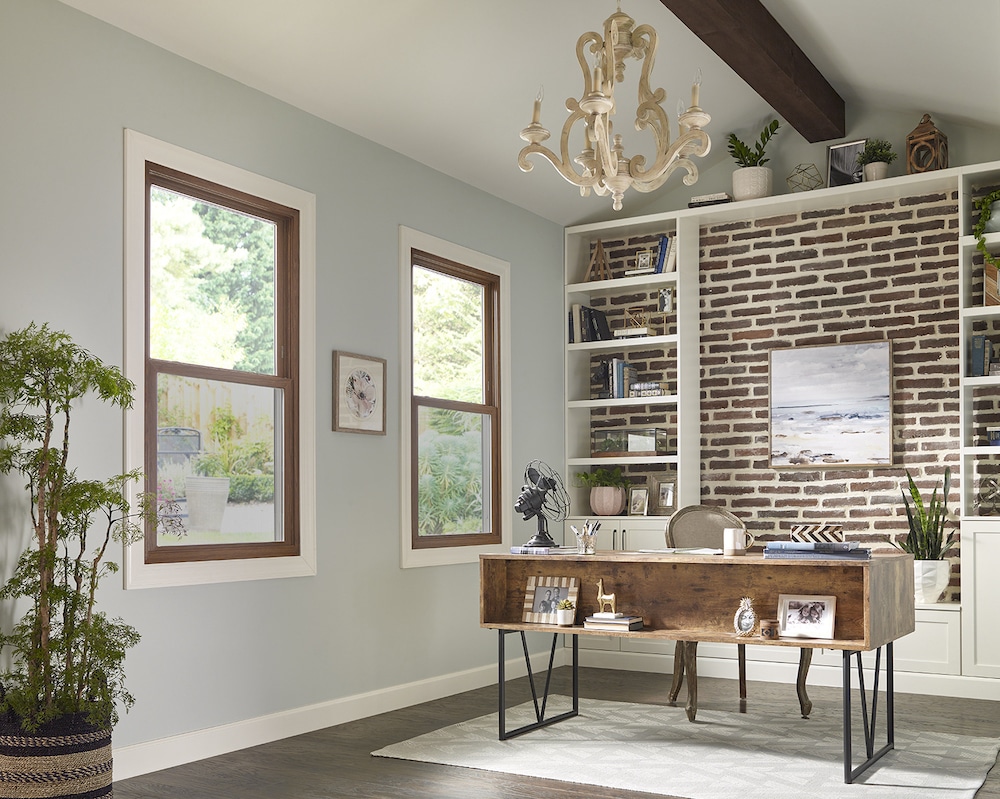 A well-decorated office with a line of double-hung windows.