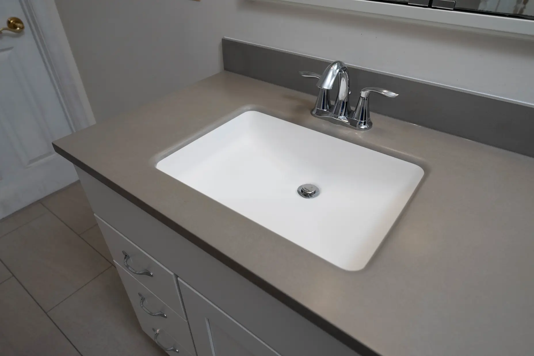 Large grey vanity and sink in a new residential full bathroom remodel from West Shore Home.