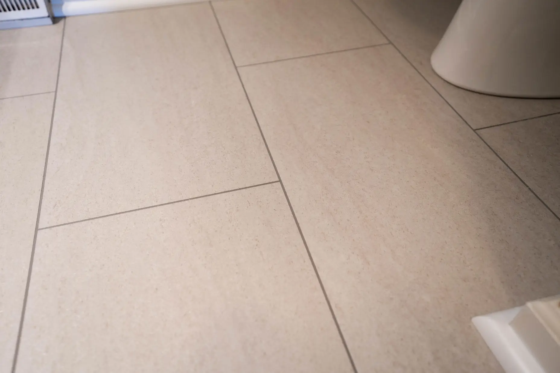 A close up image of a neutral tile, vinyl floor. 