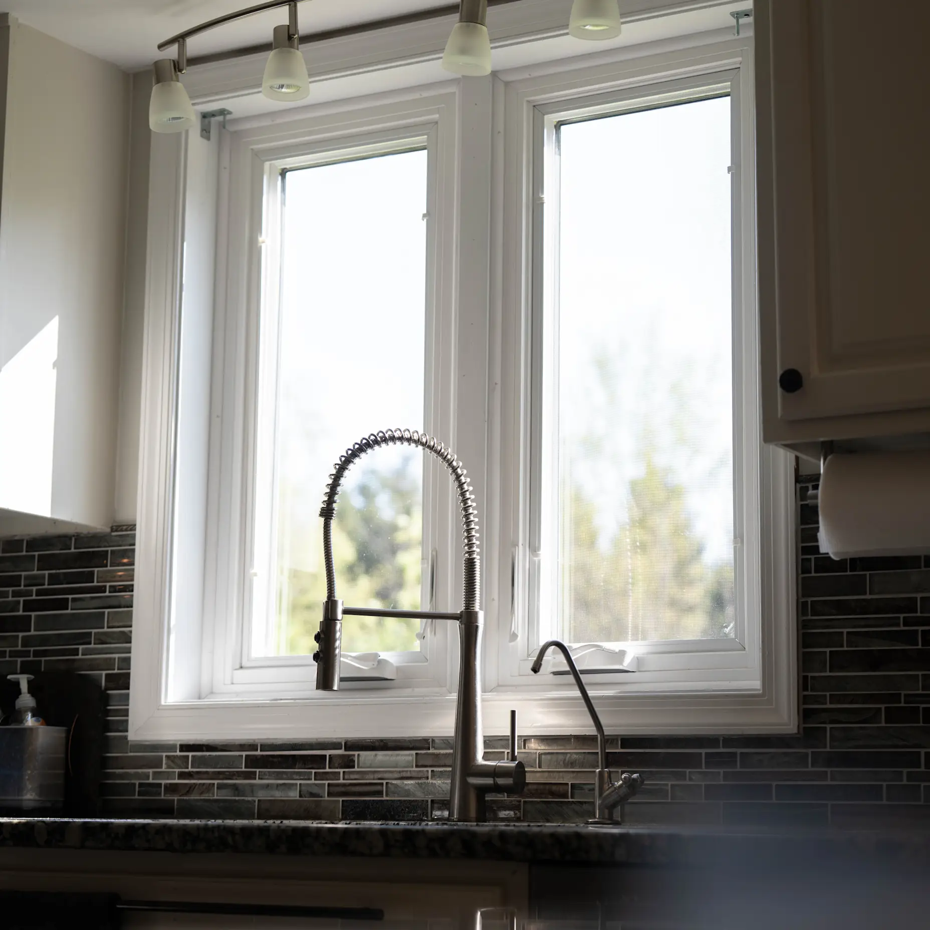 A white casement window above a kitchen sink.