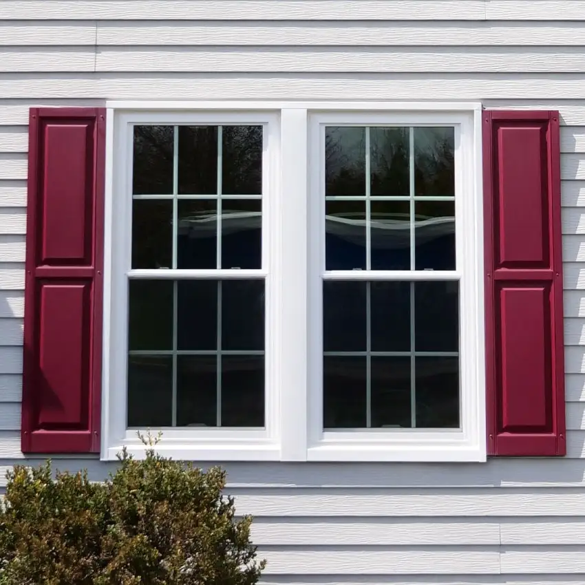 Double hung windows offset by bright red shutters.