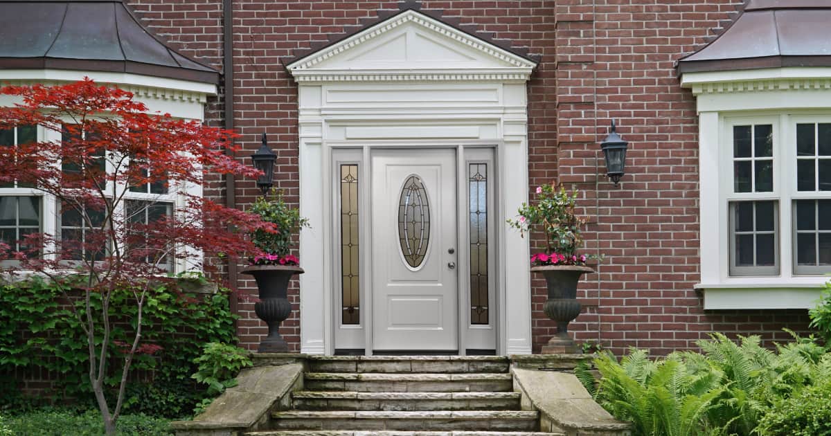 A beautiful entryway to a rustic, multi-story brick home.