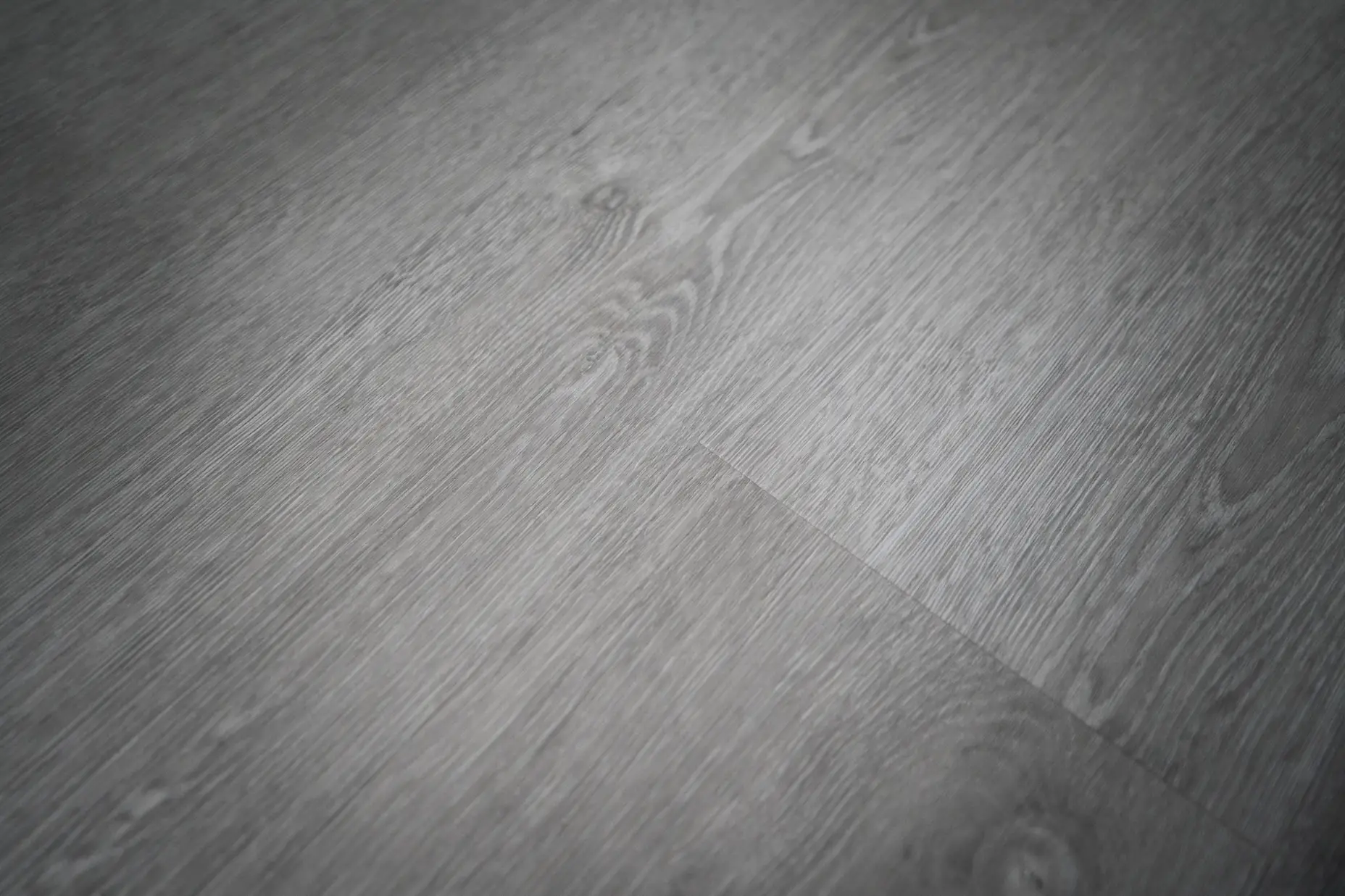 A closeup image of grey vinly plank flooring.