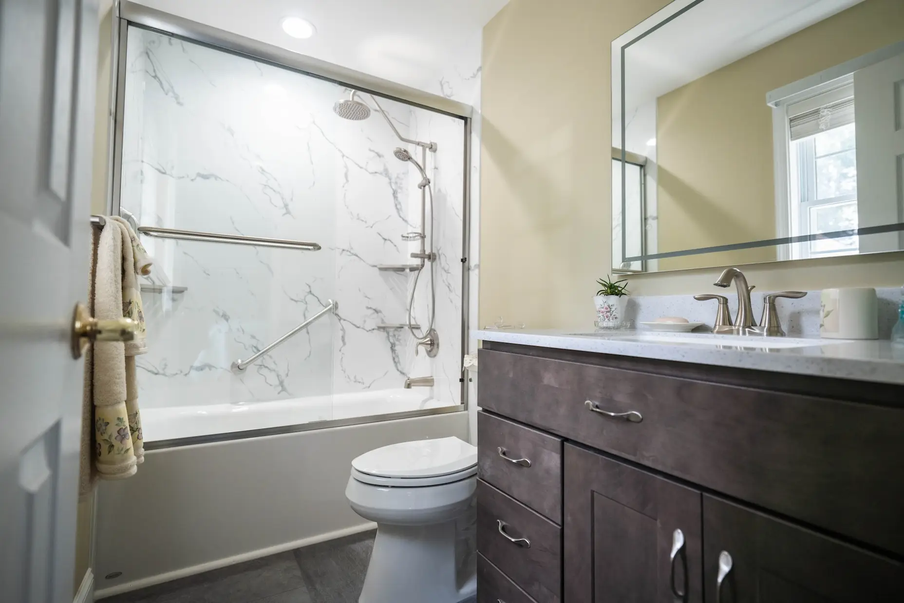 A West Shore Home tub and shower combo installation with a marble-patterned acrylic shower surround.