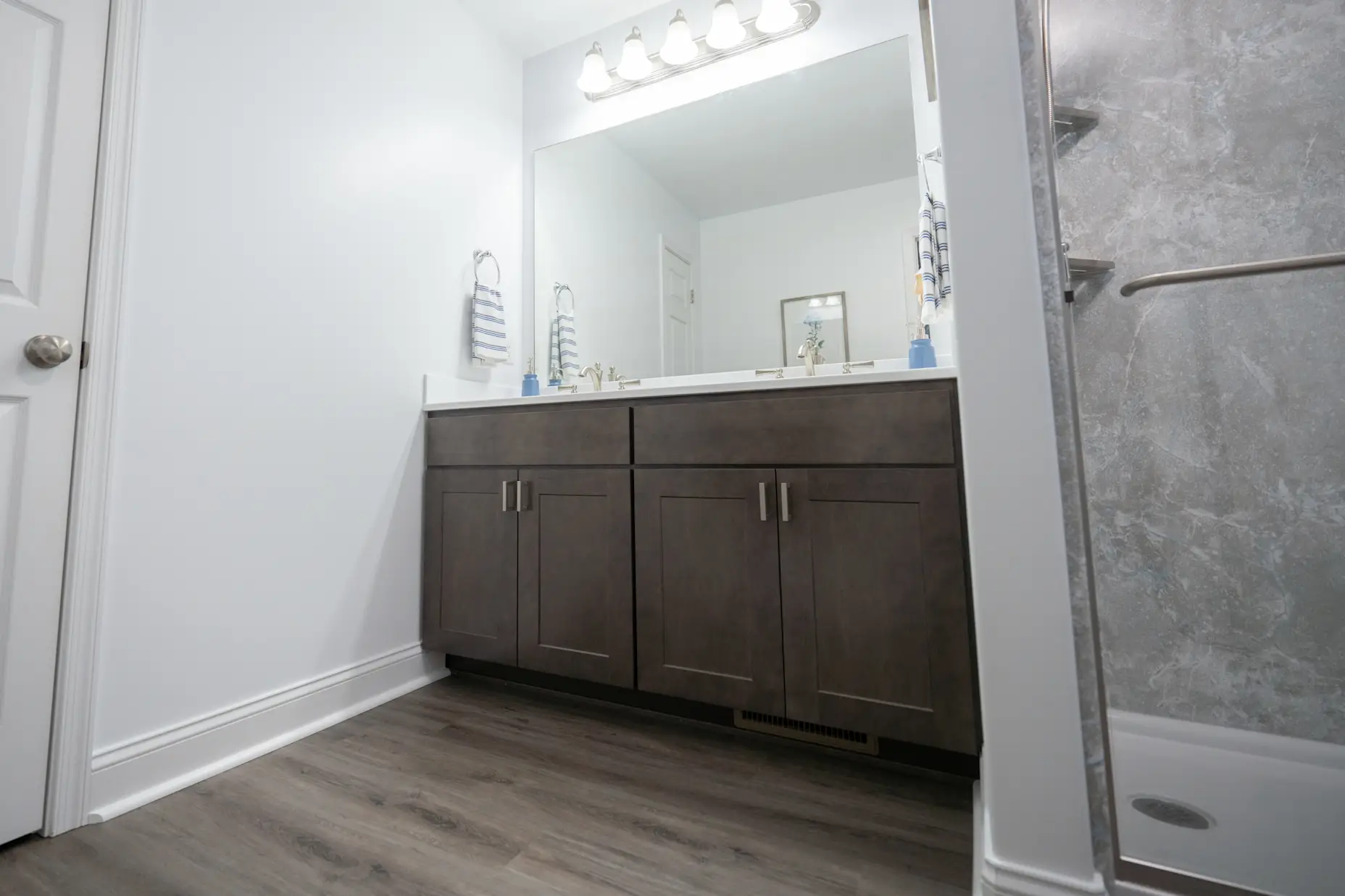 A dark brown vanity in a grey bathroom.