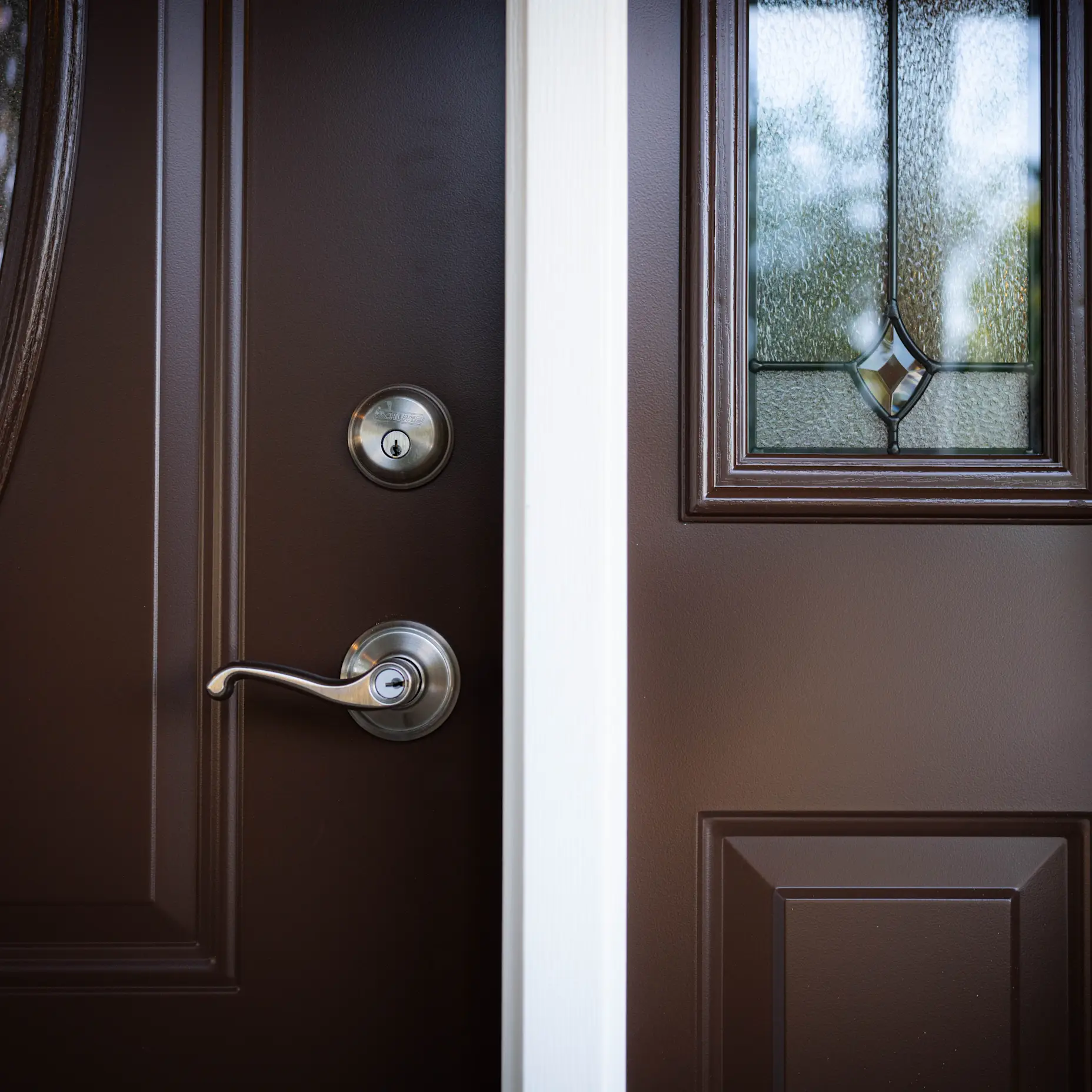 A close up image of a solid brown door with chrome hardware.