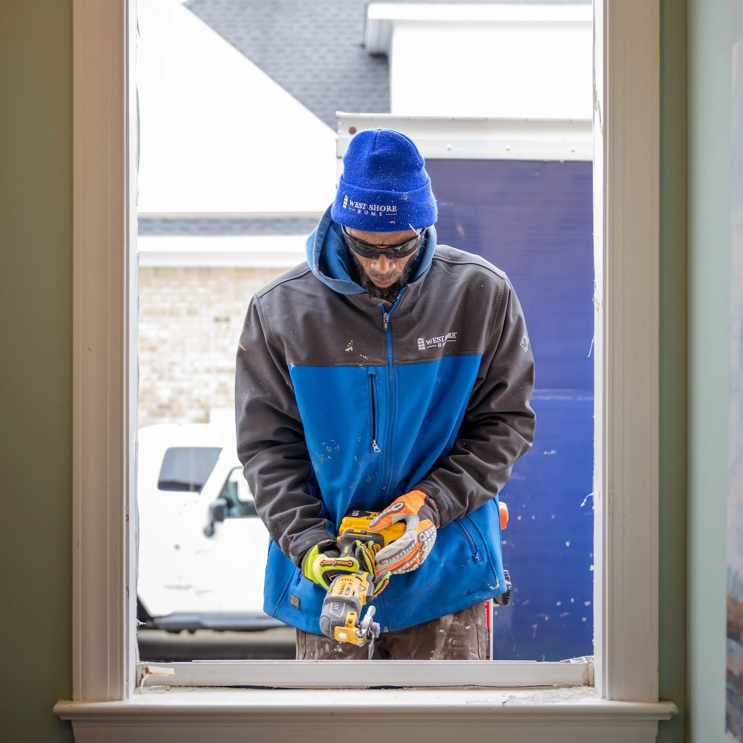 A man installing a window with a powertool.