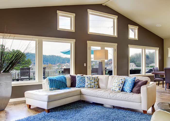 A spacious living room with a number of windows looking out onto a countryside.