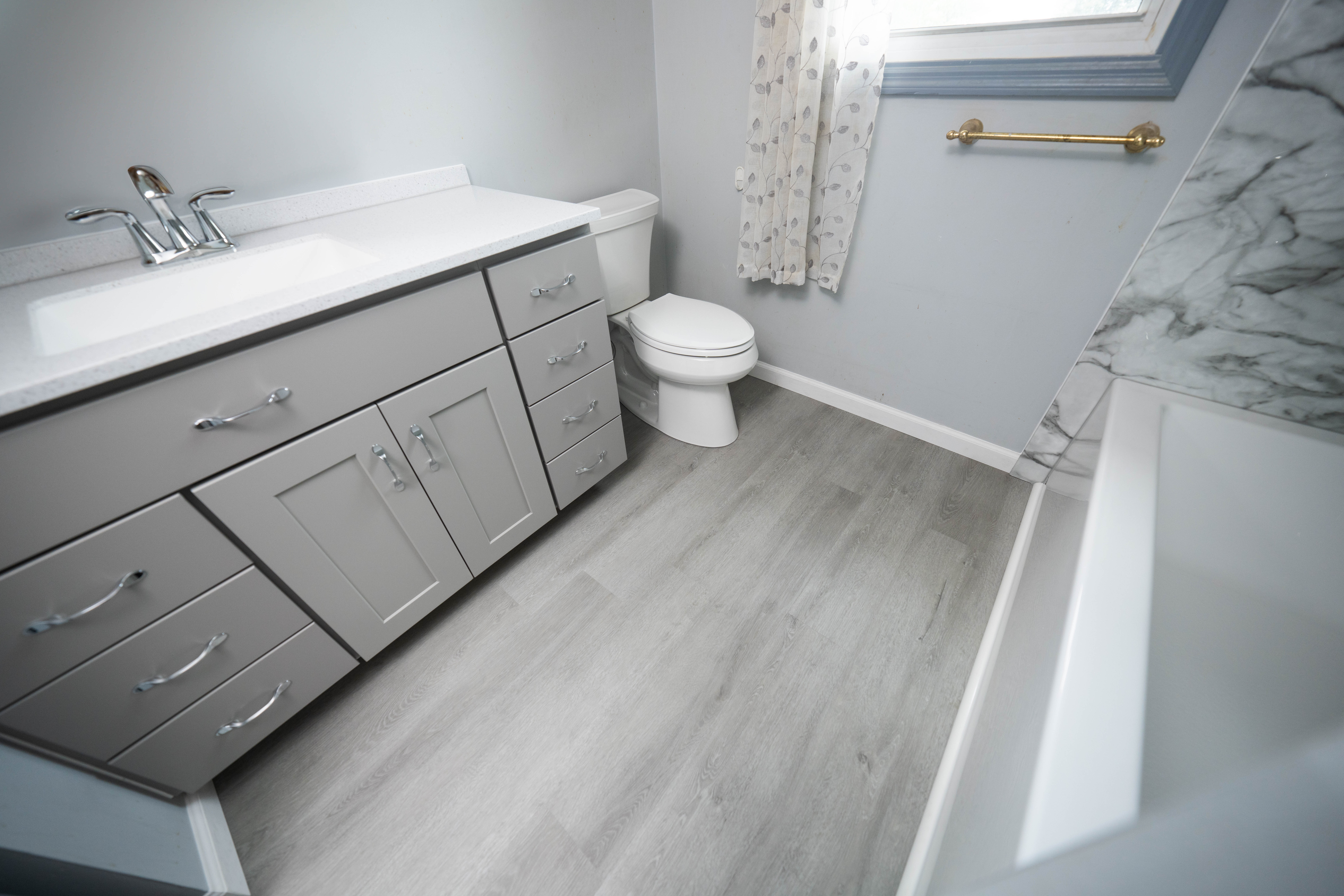 Grey luxury vinyl plank installed in a bathroom.