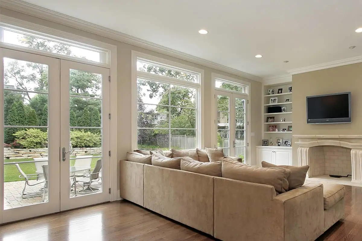 Large french door and windows in a spacious, contemporary living room with recessed lighting.