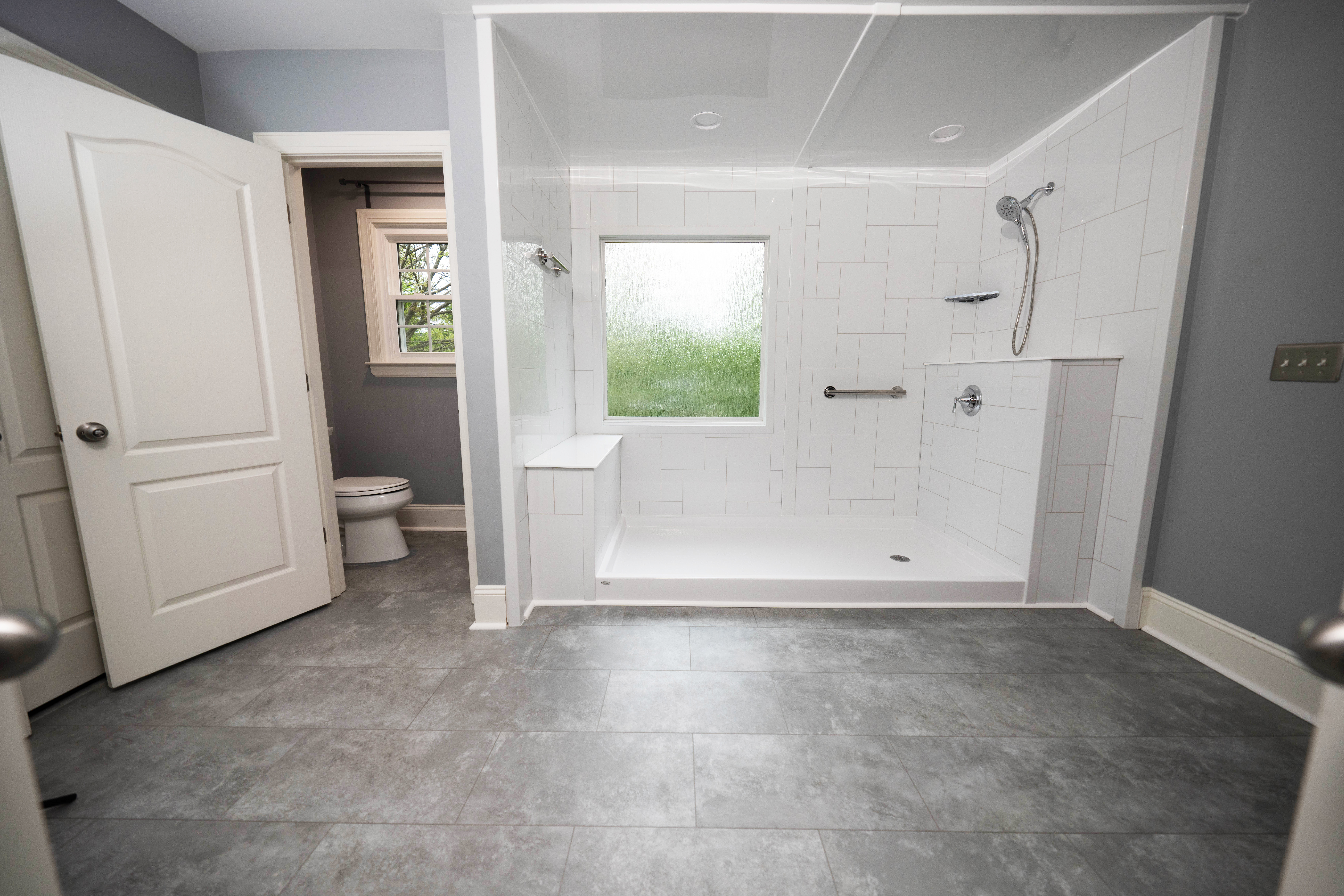 A lareg custom walk-in shower with a frosted glass picture window.