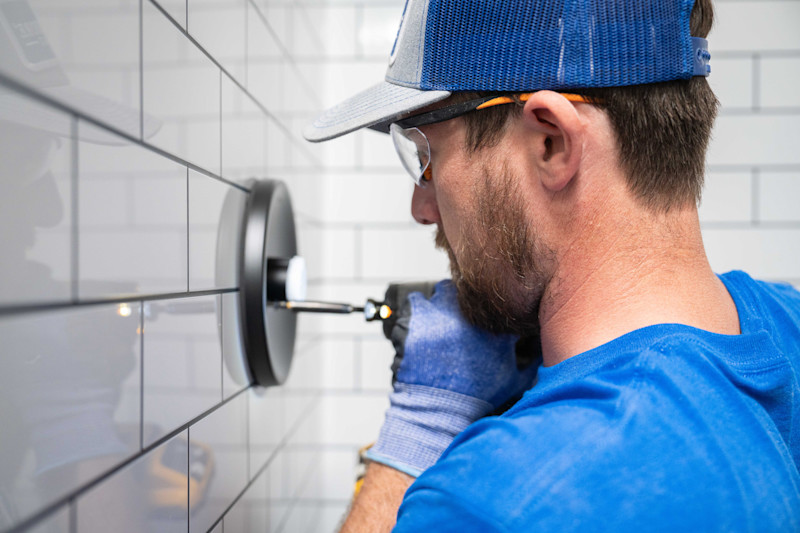 A West Shore Home installer working in a newly built shower