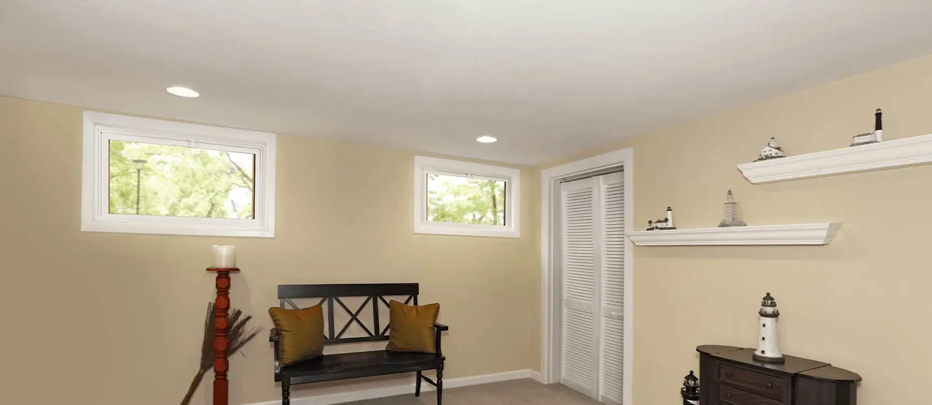 Two hopper windows in a basement with yellow walls.