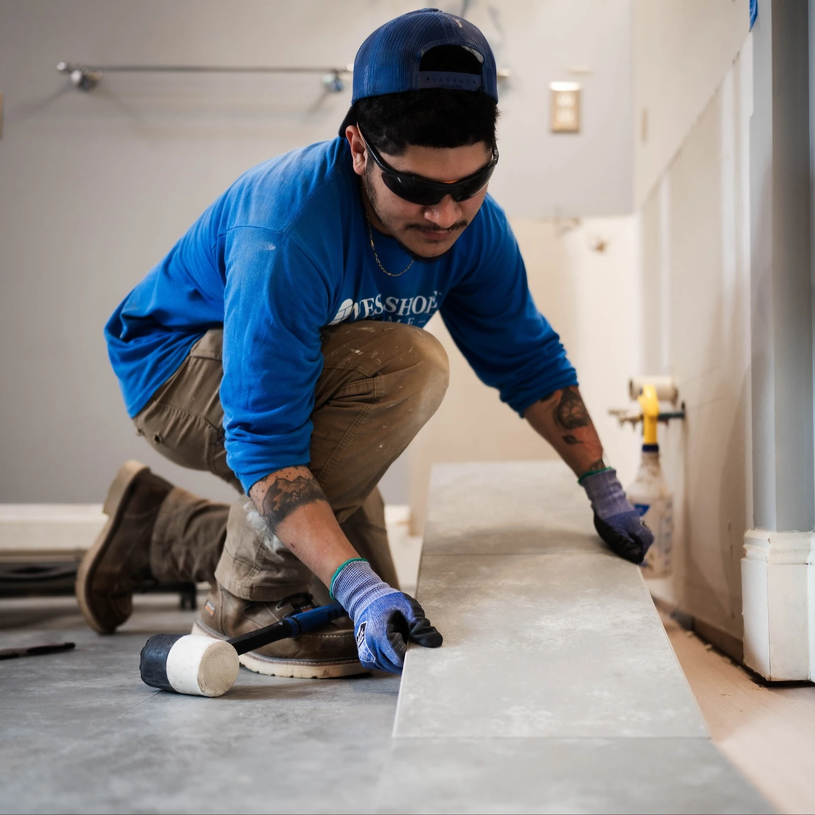 A man installing flooring into a bathroom.