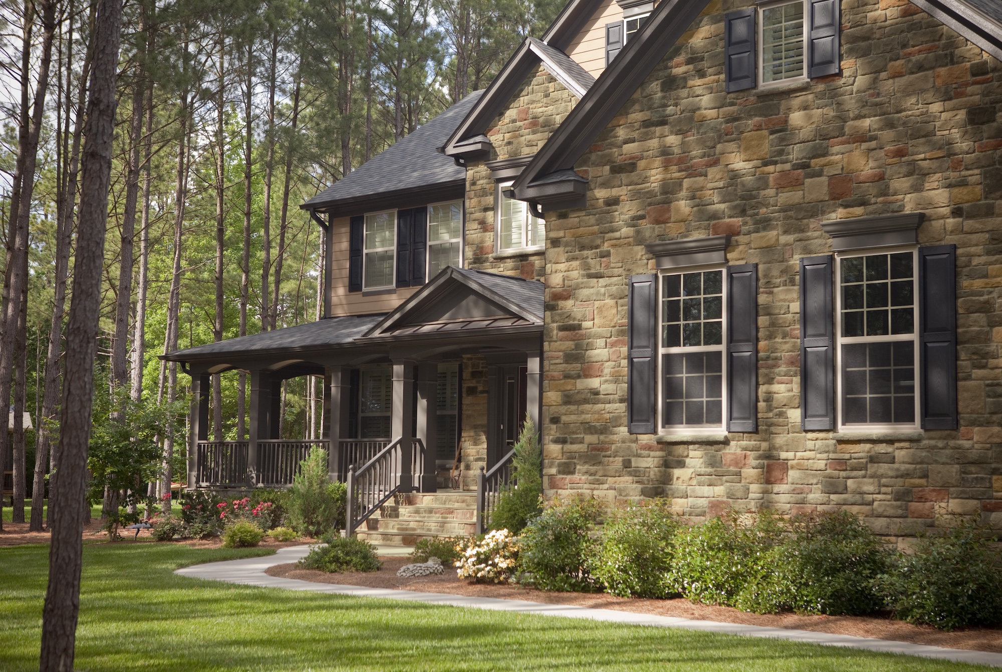 The exterior of a large home with a stone facade.