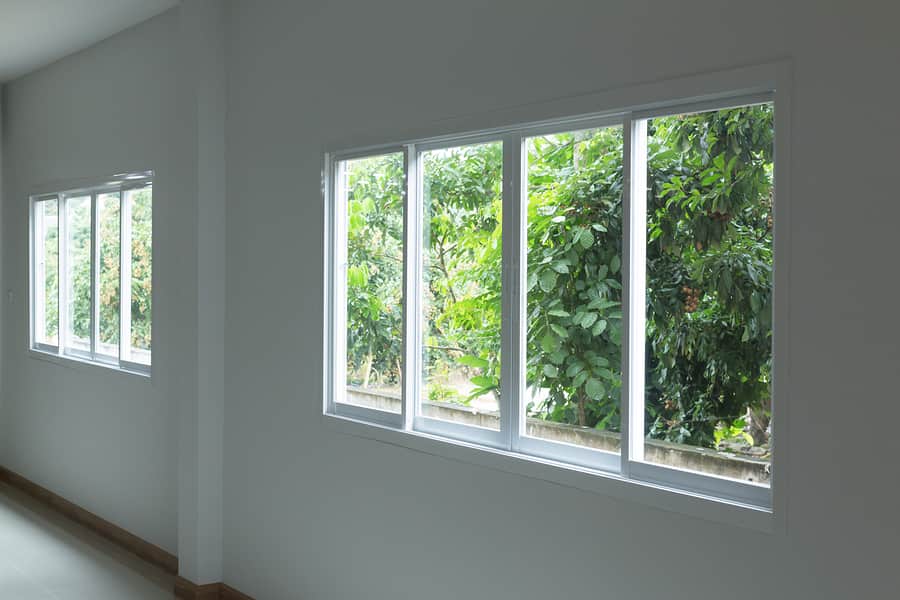An empty hallway with sliding windows looking out onto a garden.