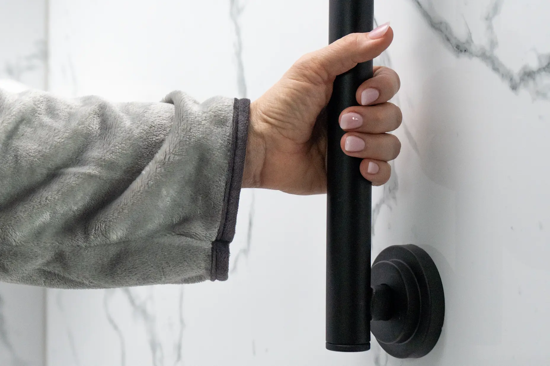 A matte black grab bar being used.