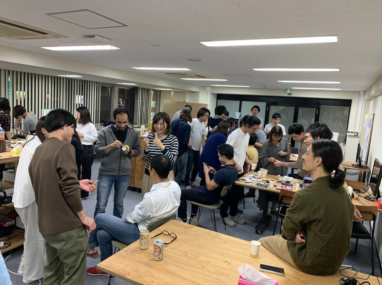 2019年のハロウィンシーズンの懇親会で黄色のペンキを塗られようとしているuzさん（白シャツ）の写真