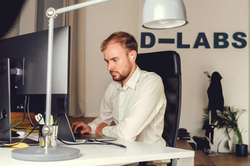 A man sits in front of a laptop at our Berlin office, highly focused on his work.