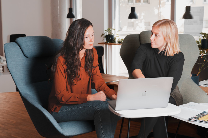 Two women sitting behind a laptop in our Berlin office. One is showing the other something on the screen.