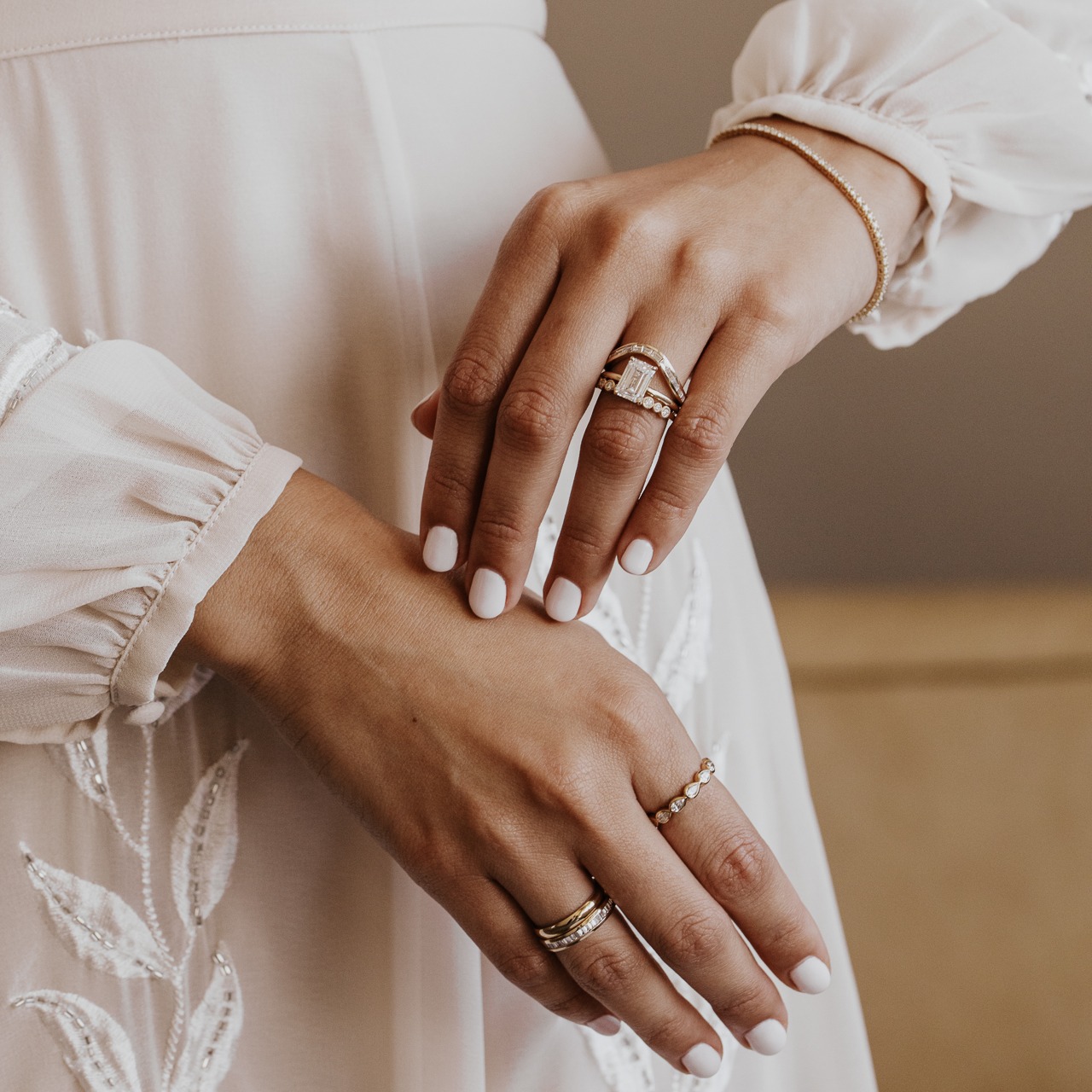 Model wearing multiple bands on both her right and left hand.