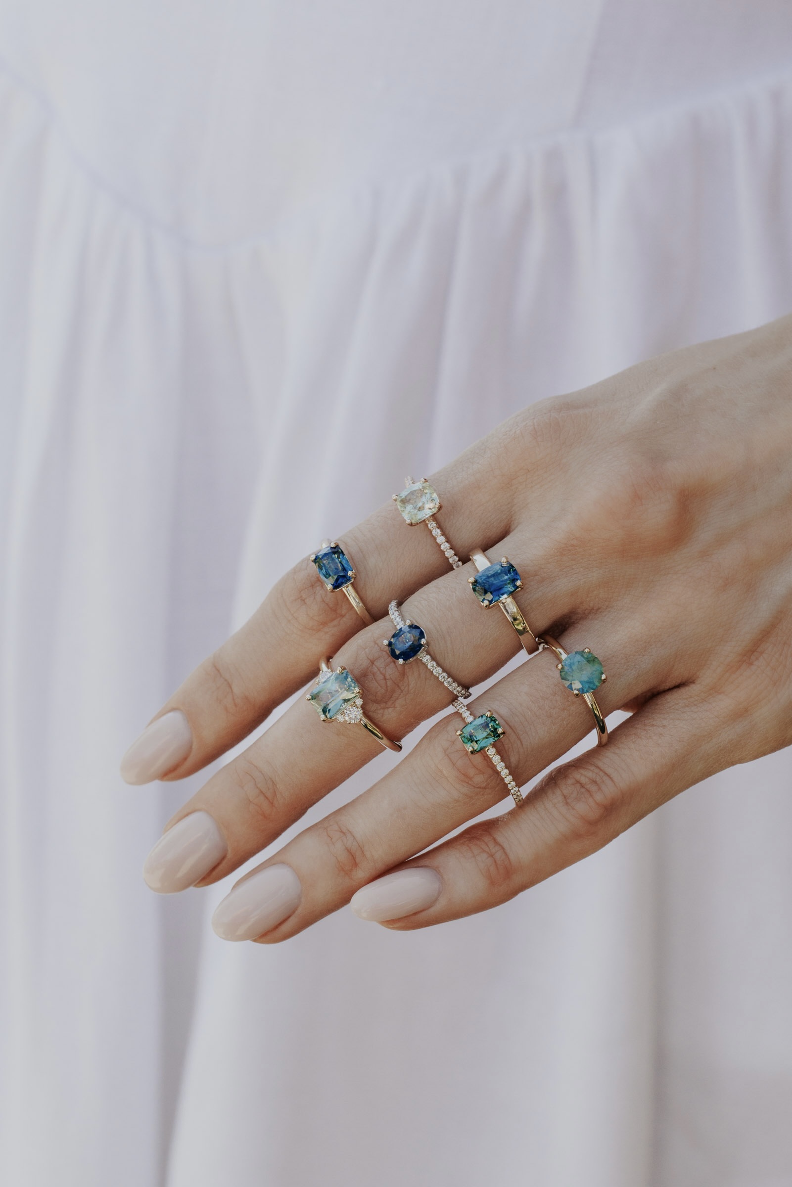 Model wearing multiple sapphire rings from the Voyage collection.