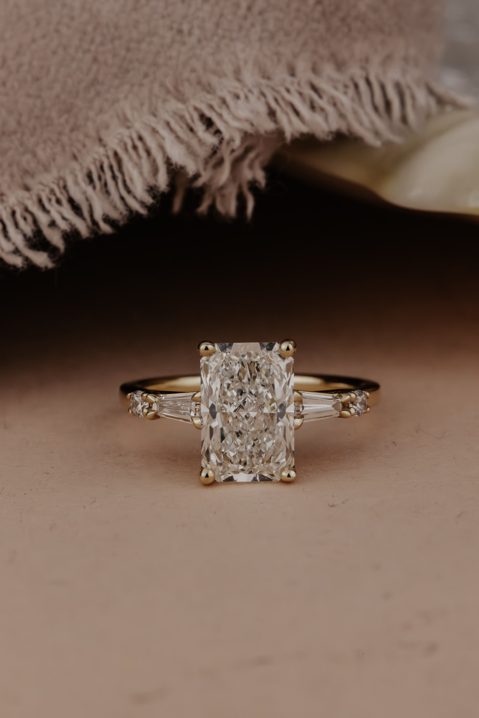 The Diane radiant diamond engagement ring on a dark surface.