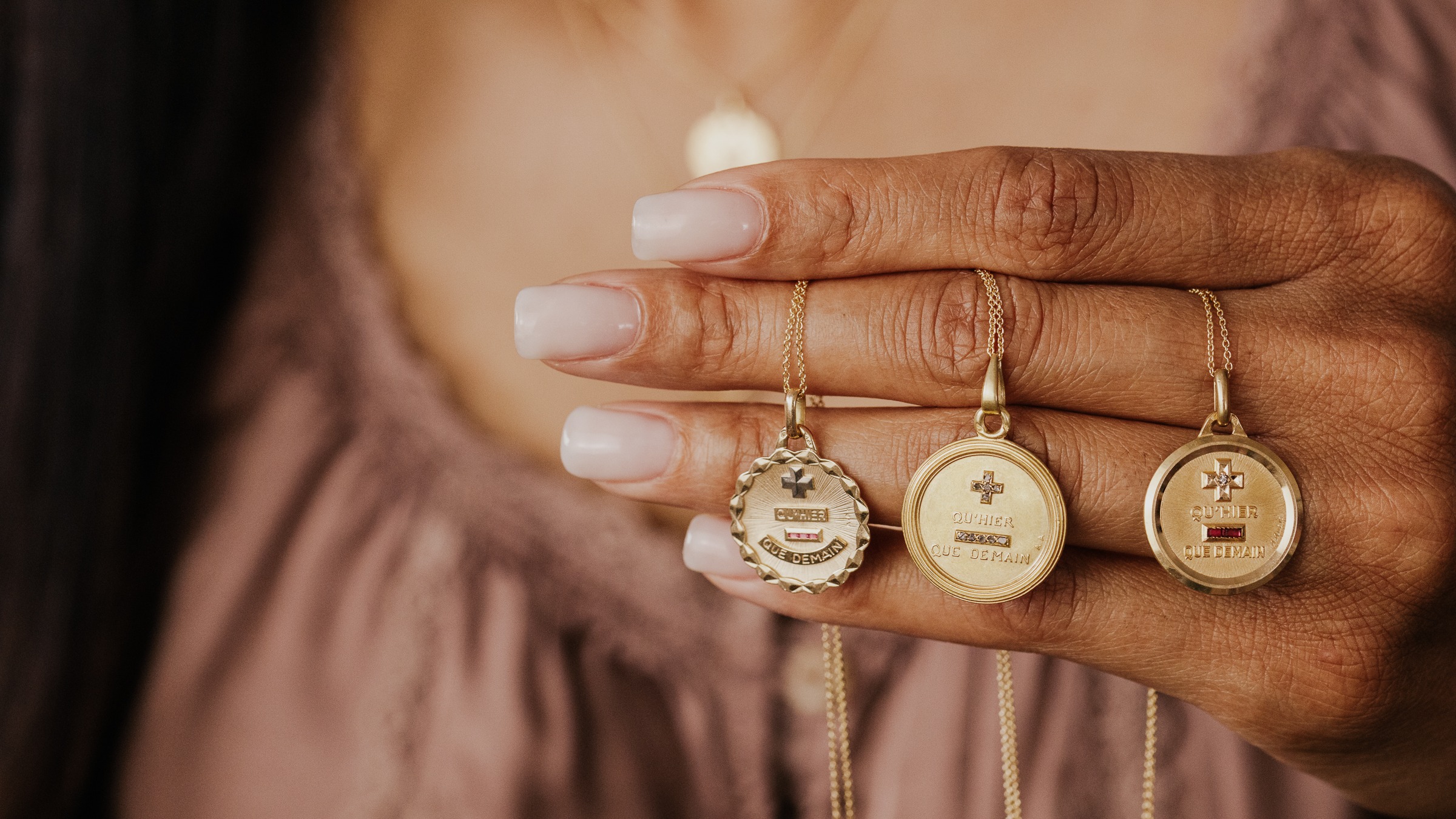 Person hold 3 gold vintage french love tokens from Paris.
