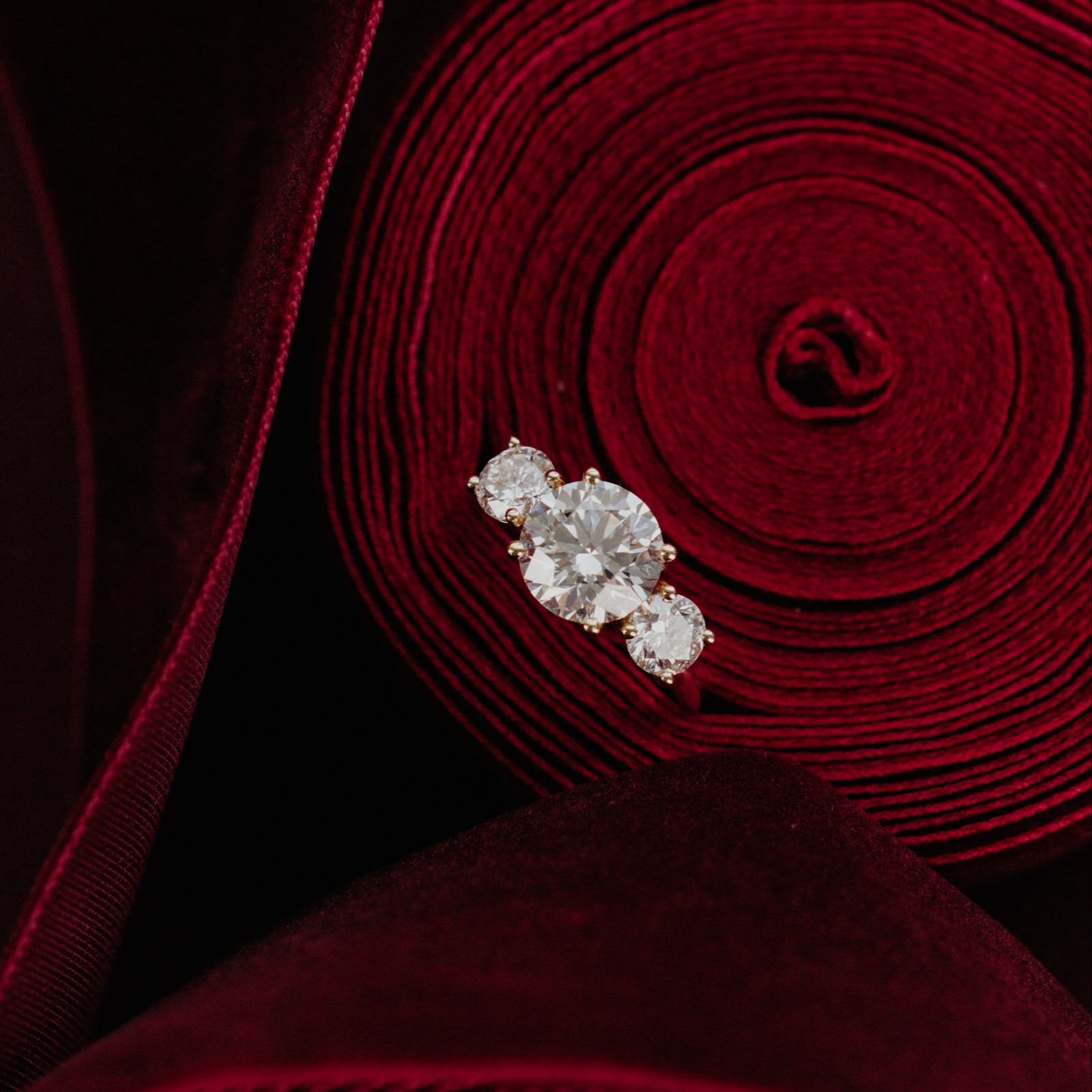 The Hannah round diamond engagement ring with a red background.