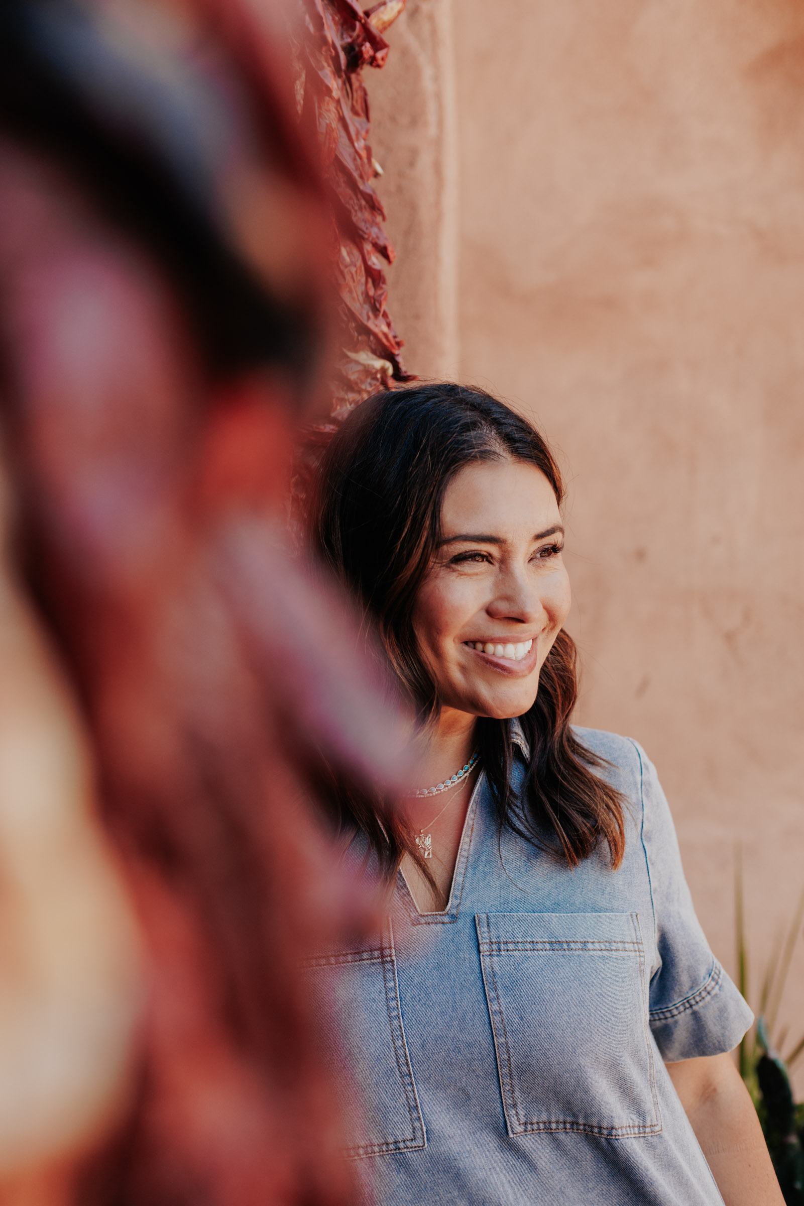 Photo of Sarah next to an adobe house