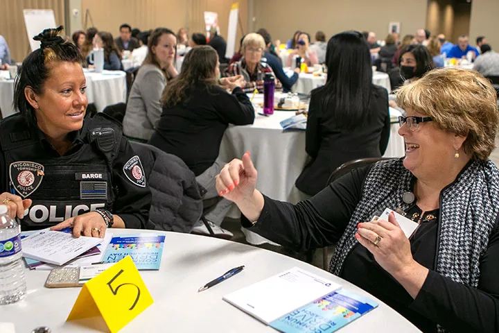A community group talking at round tables